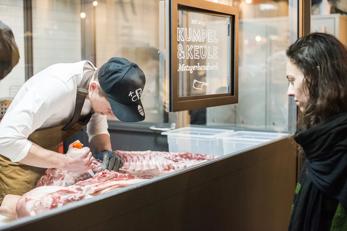 Metzger zerlegt Fleisch vor Publikum